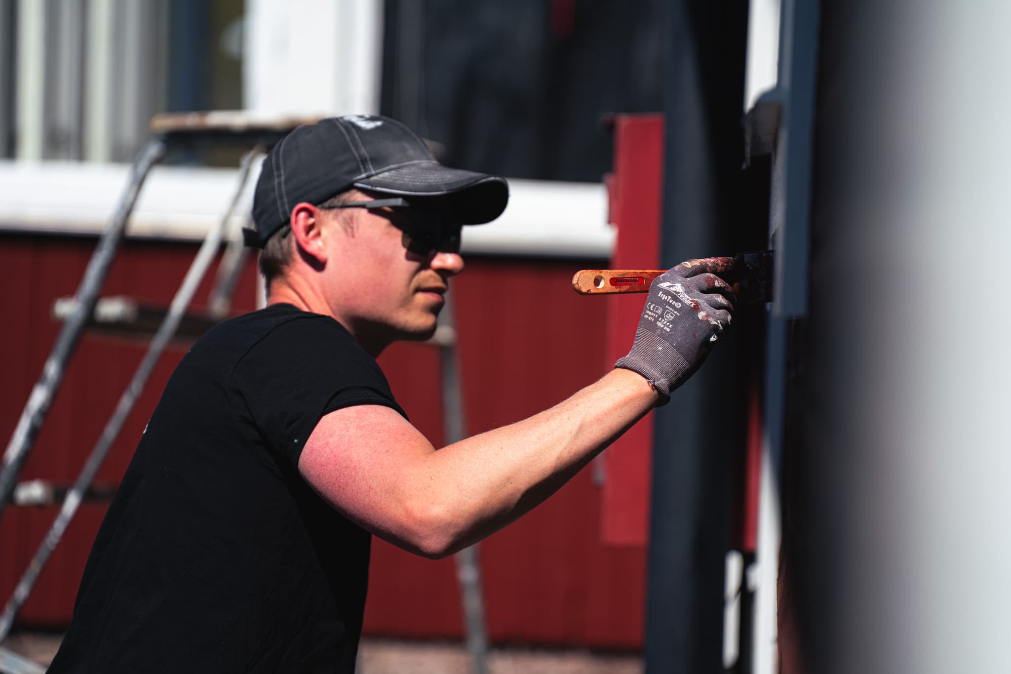 Fönstermålning i Linköping – Fönstermålning – målare målar fönsterbåge på rött hus
